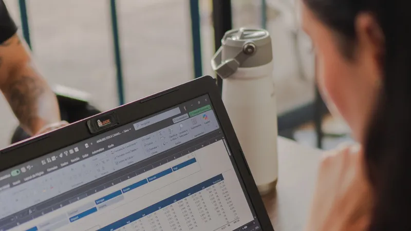 A marketer working on a laptop with spreadsheet data